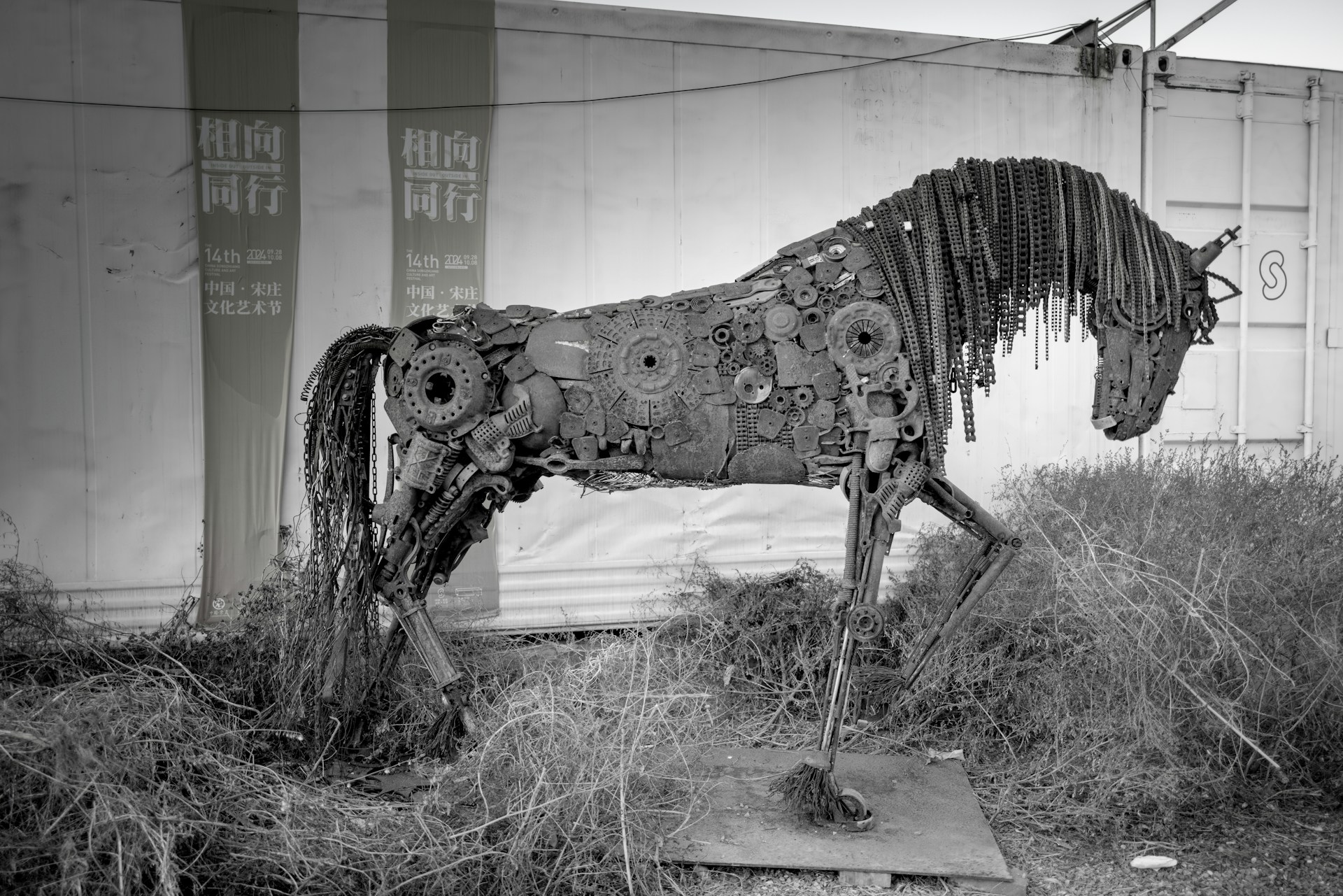 Scrap metal horse sculpture in a field.